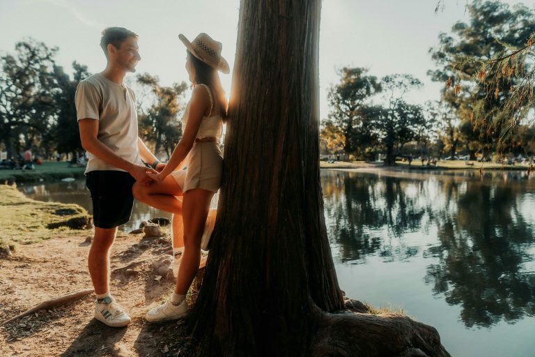 Young couple sharing a romantic moment by a tree in a Buenos Aires park. Perfect for lifestyle themes.